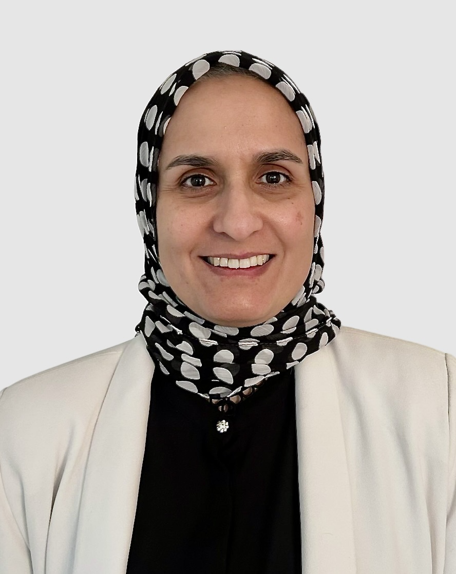 Woman wearing a patterned hijab smiles at the camera.